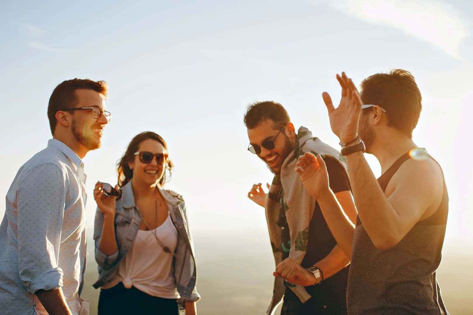 Three men and one woman laughing during daytime