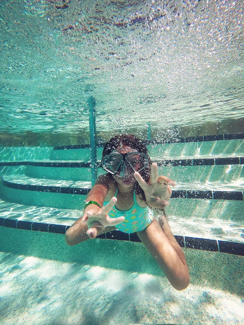 Girl Giving Peace Sign Under Water