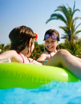 kids splashing and playing in pool with tube