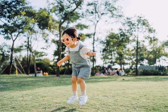 Happy Girl in Flower Sunglasses Jumping in Park