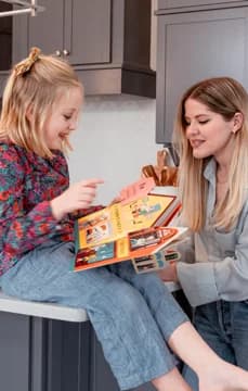 Child Playing with Book in Kitchen Looks Photoshoot