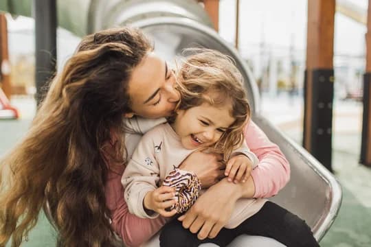 Mother and Daughter on Slide in Playground