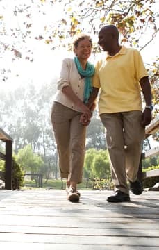 Older Couple Walking in Nature on Bridge USP Crop