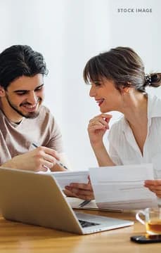 161968 Smiling Young Couple Going Over Documents on Computer Crop DCA USP Crop