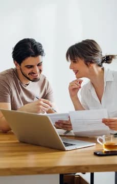 161960 Smiling Young Couple Going Over Documents on Computer USP Crop